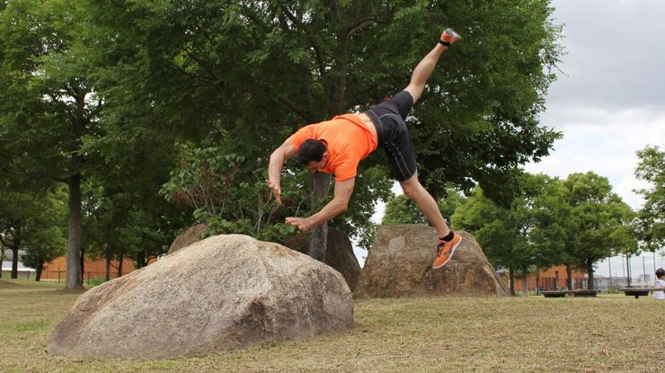 Practicing a cartwheel leap over a rock